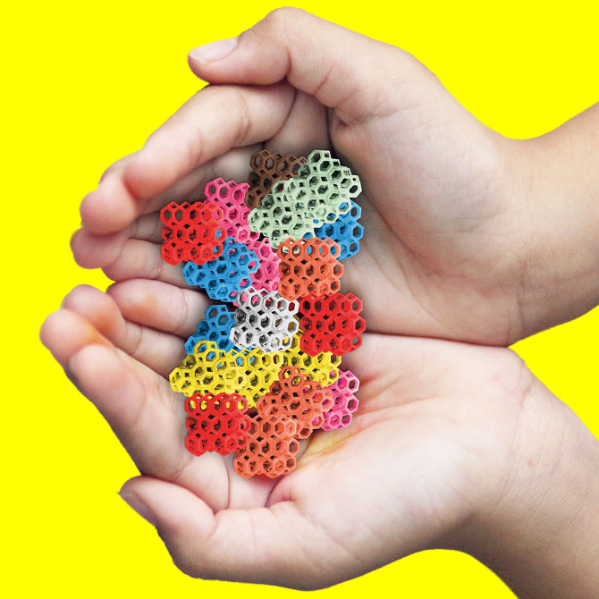 a hand holding a pile of small candy in different shapes