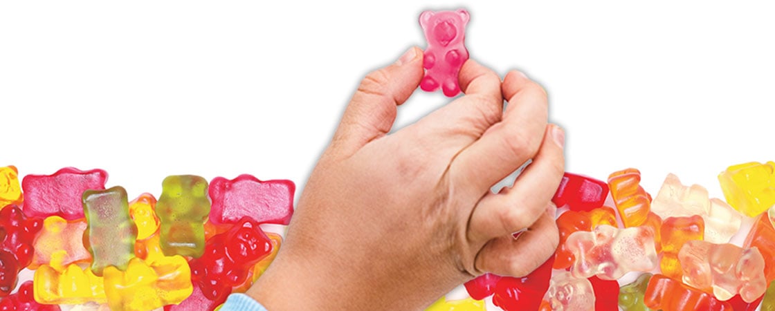 A hand pinching a gummy bear